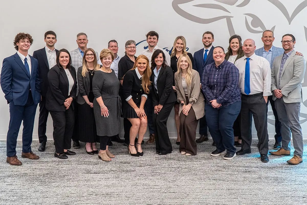 team-members-posing-in-front-of-bull-wall-smiling-at-camera team-members-posing-in-front-of-bull-wall-smiling-at-camera