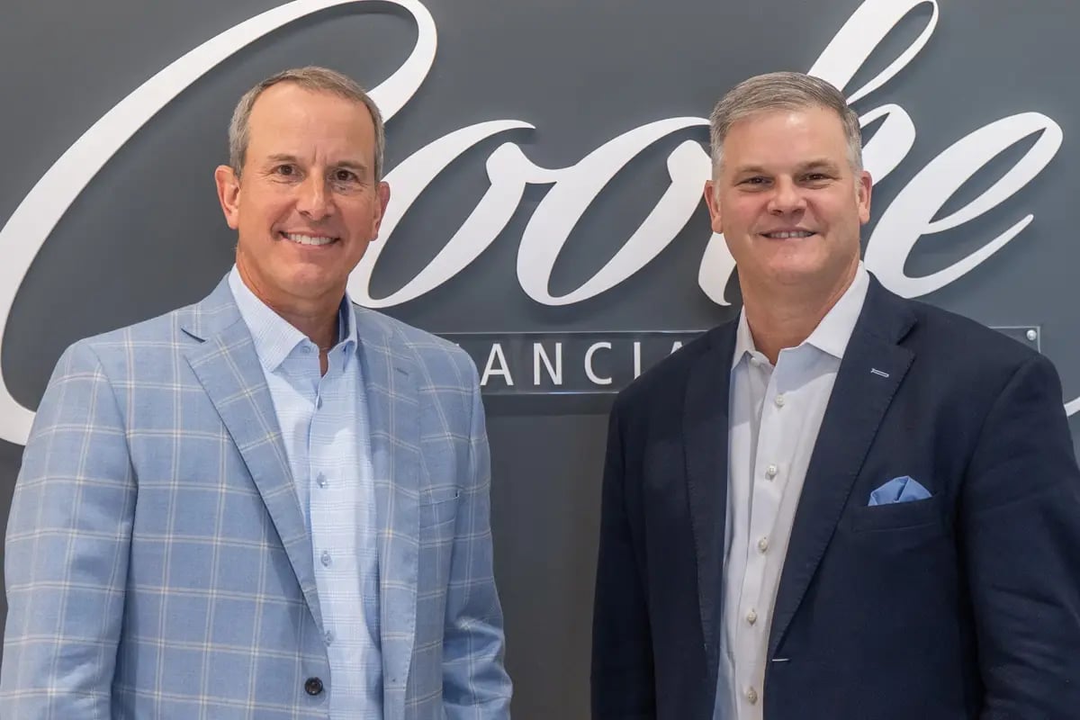 Wealth advisors standing and smiling in office